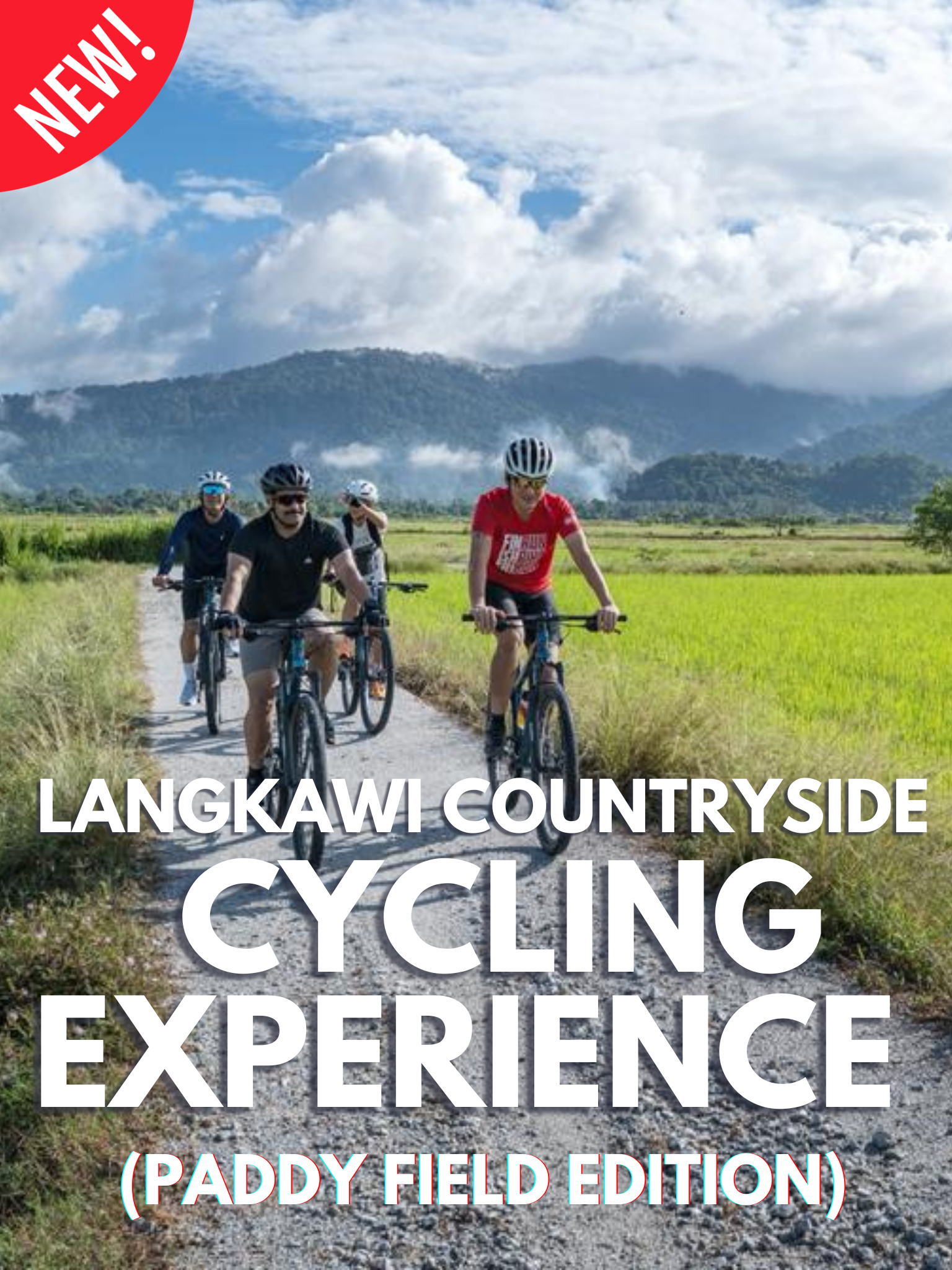 Four people riding mountain bikes on a path through lush green paddy fields in Langkawi, with a mountain range and cloudy sky in the background. A red "NEW!" sash is in the top left corner, and the text "LANGKAWI COUNTRYSIDE CYCLING EXPERIENCE (PADDY FIELD EDITION)" is overlaid in white.